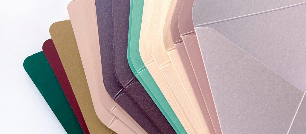 Віяло кольорових конвертів: зелений, бордовий, фіолетовий, пудровий, бежевий, сірий